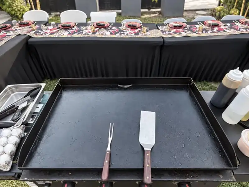 On-site hibachi chef at the outdoor grill with a private catering dining setup